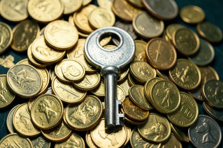 Quanto custa uma avaliação imobiliária? Chave de casa e moedas.